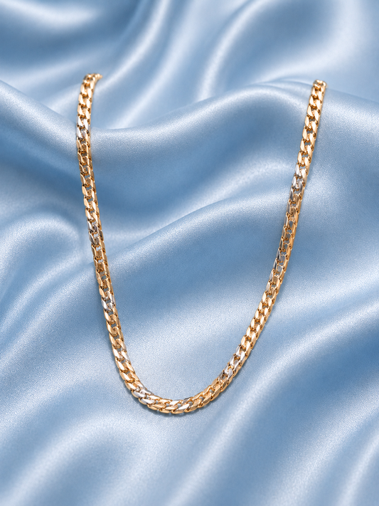 A gold-toned curb chain necklace draped in a U-shape over draped light blue satin fabric.